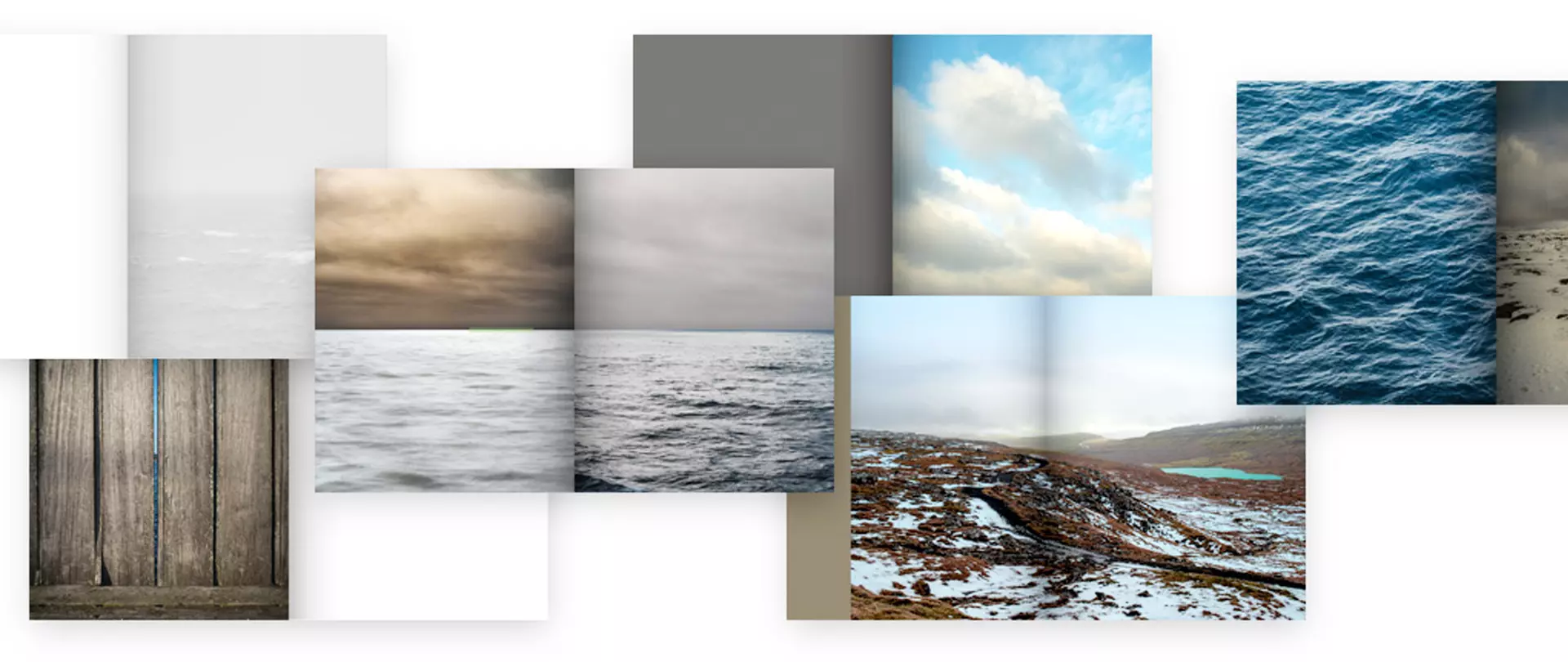 Mehrere geöffnete Fotobücher mit Landschafts-, Wasser- und Holzbildern als Beispiele für künstlerische Fotobuchgestaltung