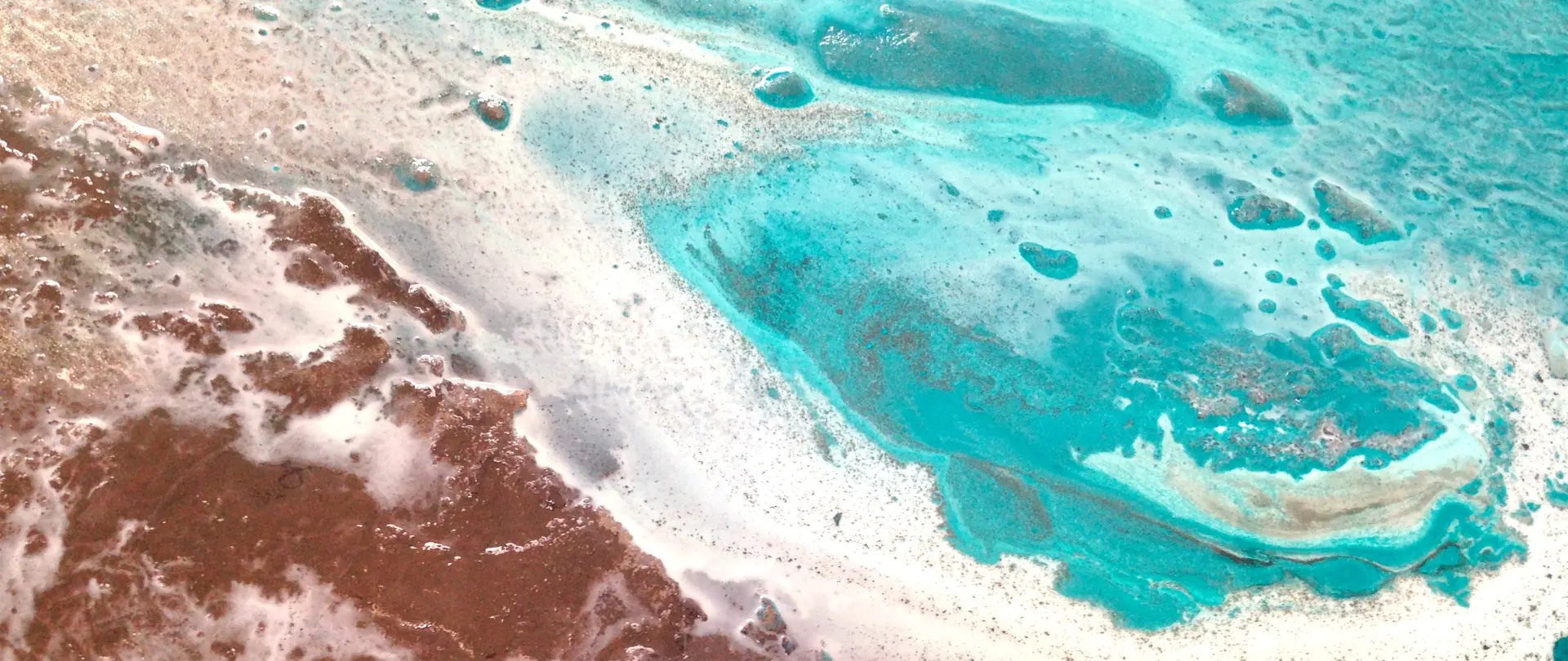 Abstrakte Luftaufnahme von Sylt mit kontrastreichem türkisblauem Wasser und braunen Landflächen, inspiriert von Natur und experimenteller Malerei