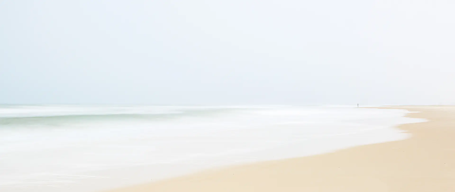 Weißer Sandstrand und sanftes Nordseewasser auf Spiekeroog mit ruhiger, nebliger Atmosphäre für Natur- und Landschaftsfotografie
