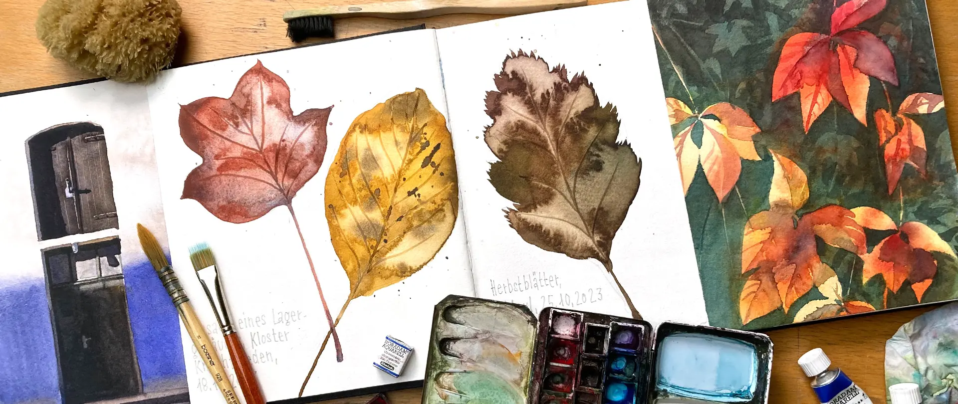 Aquarell Thomas Haubold Aquarell-Skizzen von Herbstblättern, Pinsel und Farbkasten auf einem Tisch als Inspiration für kreative Entdeckungsreise mit Farbe und Pinsel