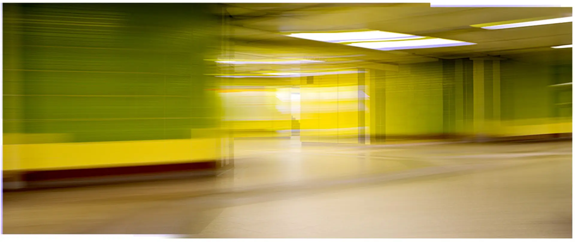 Verwischte, farbige Wände und Decke in einem Gang, experimentelle Fotografie mit ungewöhnlicher Perspektive und Bewegungseffekt