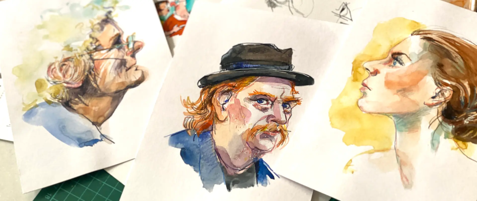Drei Aquarell-Portraitzeichnungen von Köpfen im Profil mit unterschiedlichen Blickwinkeln und Stilen auf weißem Papier