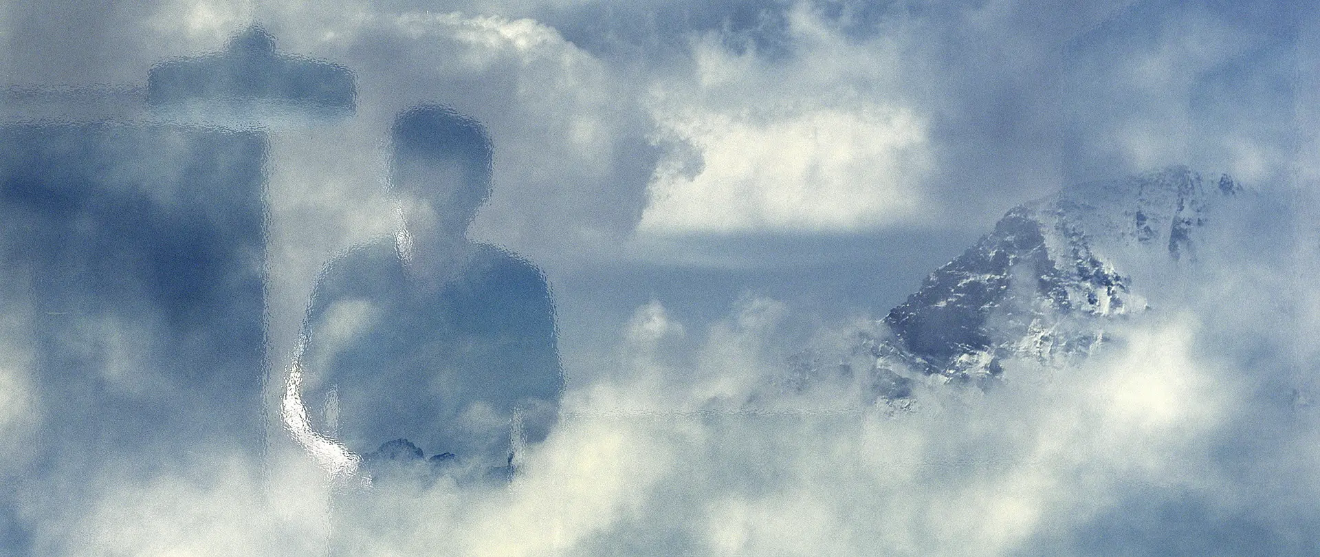 Menschliche Silhouette im Nebel vor Bergkulisse symbolisiert Selbstreflexion und innere Suche im After Work-Kurs "Ich sehe mich. Und? Wer bin ich?"