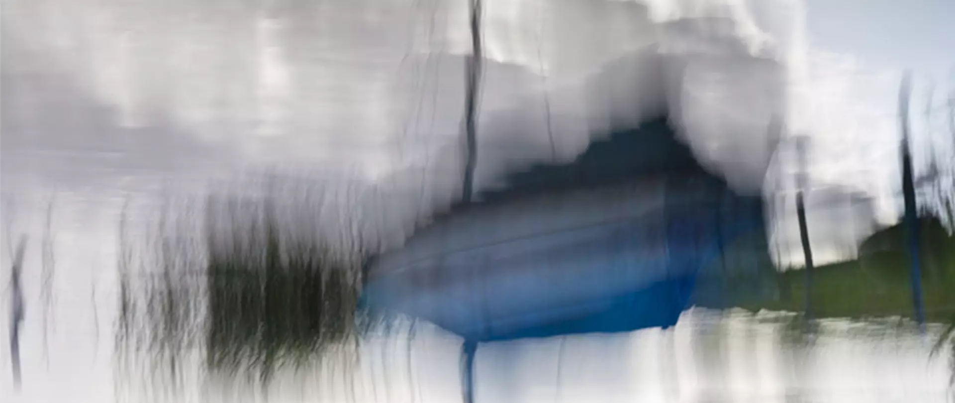 Abstrakte Langzeitbelichtung eines Bootes auf Wasser mit verschwommenen Licht- und Farbspuren als Beispiel für kreative Lichtmalerei