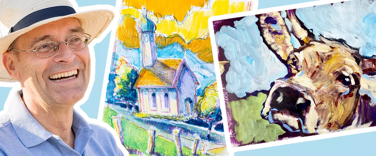 Mann mit Hut lächelt vor farbenfrohen Acrylbildern von Kirche und Esel im kreativen "Offenes Atelier" Mal-Kurs mit Sebastian