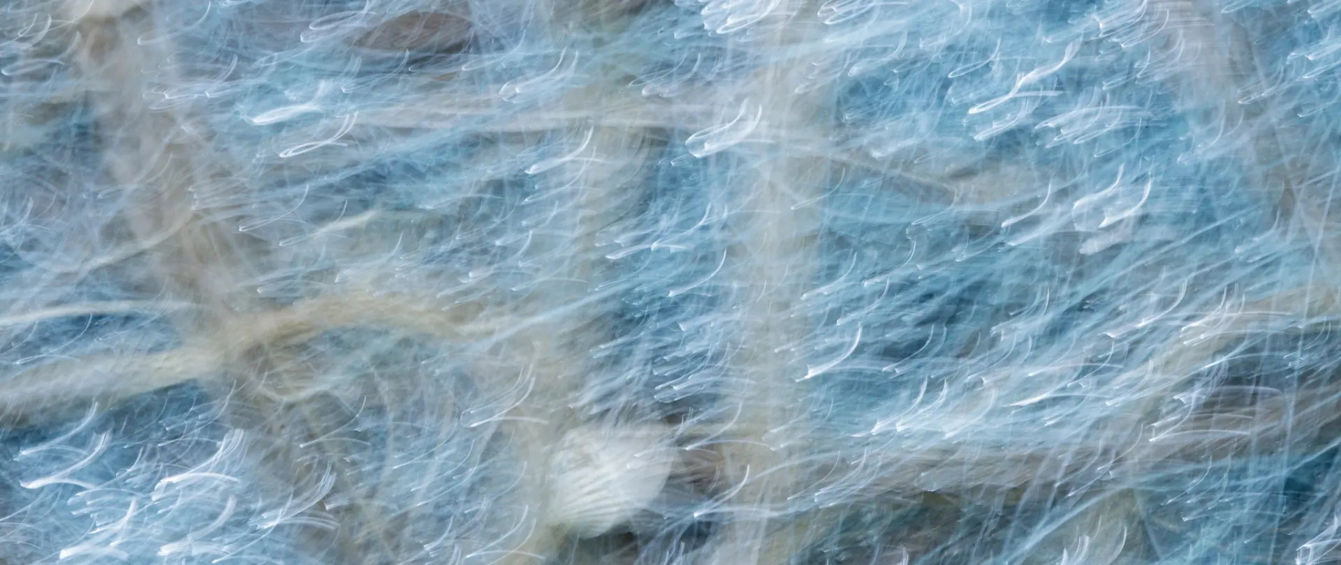 Verwischte, abstrakte Meeres- und Sandstrukturen als kreativer Ausdruck experimenteller Fotografie auf Borkum