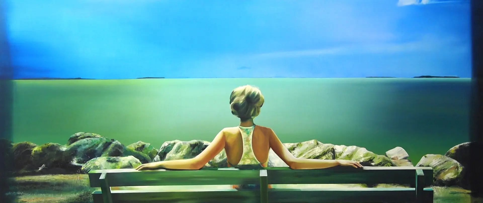 Frau mit Hochsteckfrisur sitzt auf einer Bank und blickt auf ruhiges Meer und bewölkten Himmel, vermittelt Stimmung durch Licht, Farbe und Perspektive der Küstenlandschaft