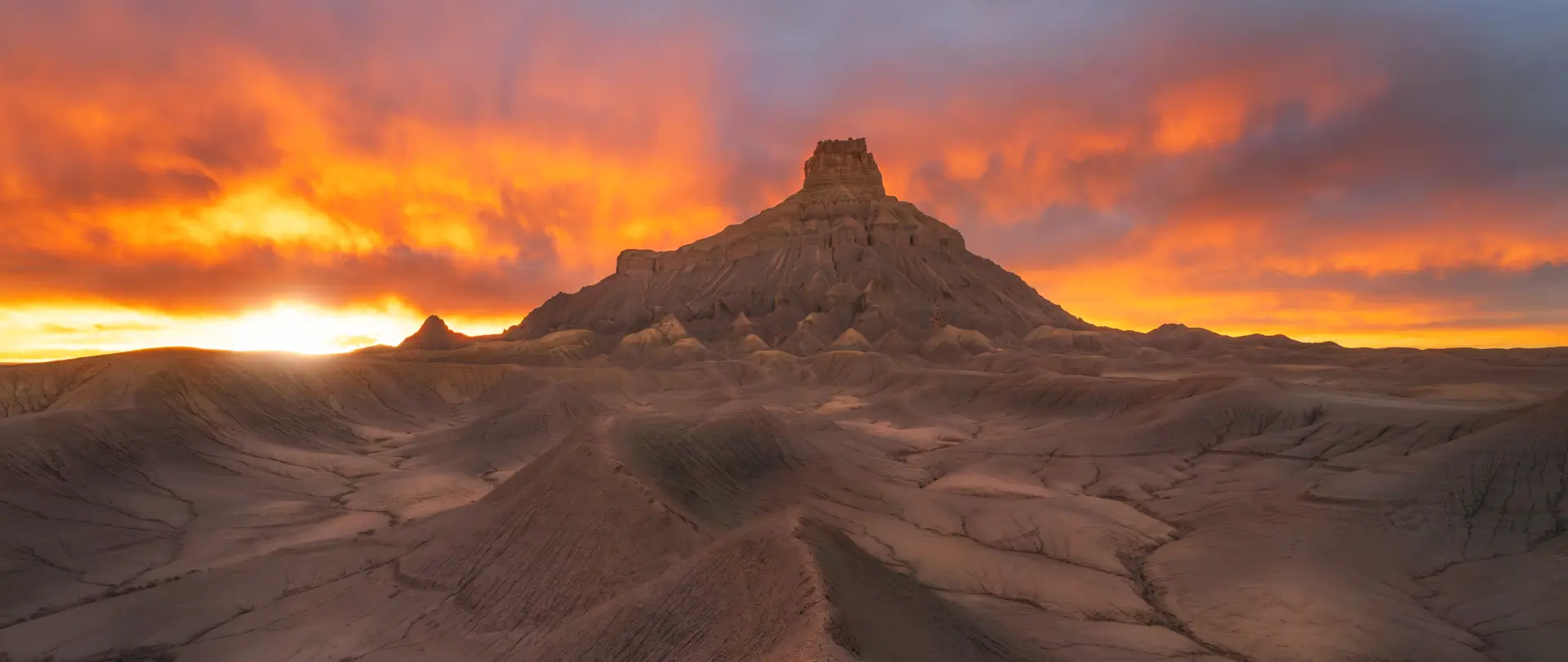 Flammend roter Sonnenuntergang mit dramatischem Himmel über einer kargen Felslandschaft, der Atmosphäre und Stimmung in der Landschaftsfotografie betont