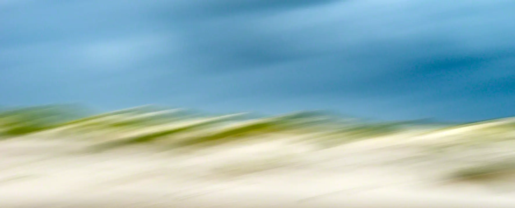 Kreativ fotografierte Dünenlandschaft mit Himmel und Grünen Farbakzenten fotografiert von artistravel Dozentin Jutta Engelage