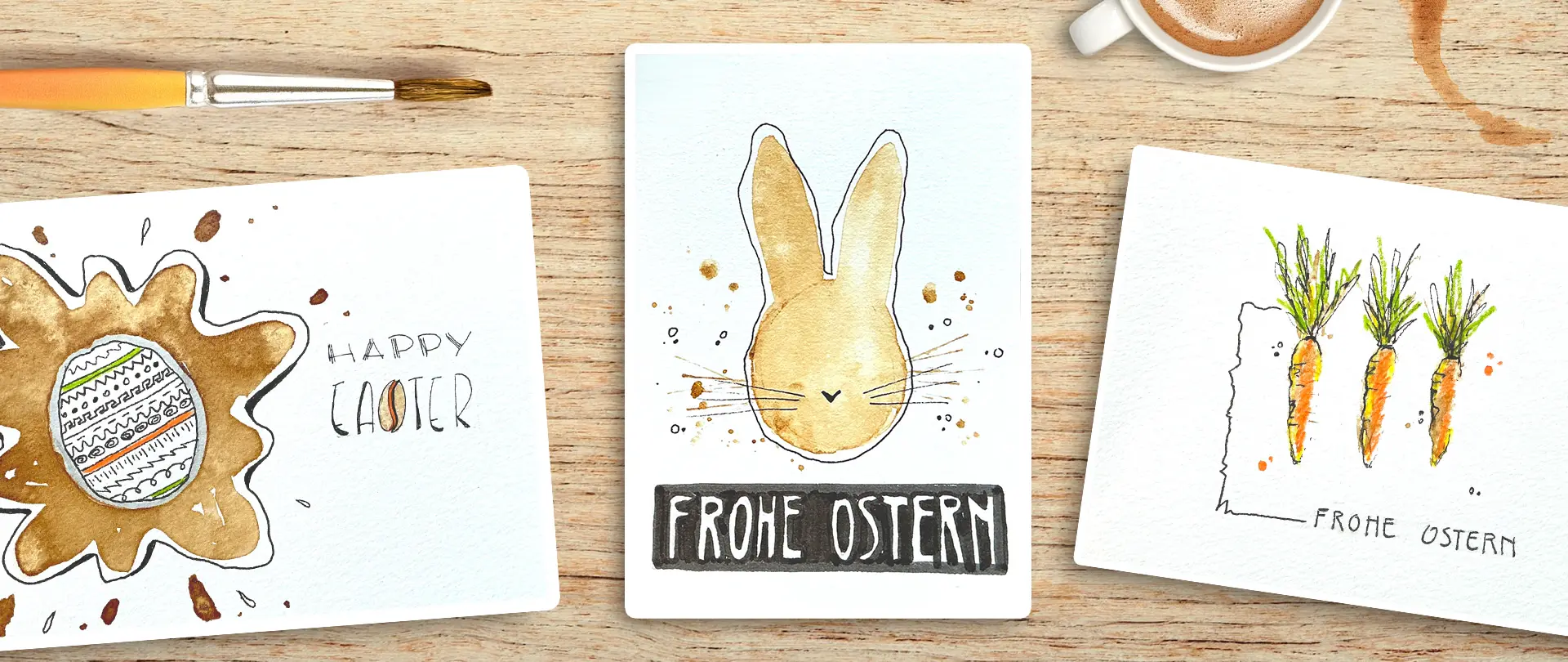 Osterkarten mit Kaffeeflecken, Aquarellhasen und Buntstiftmöhren auf Holztisch neben Kaffeetasse, kreativ gestaltet beim After Work Kurs