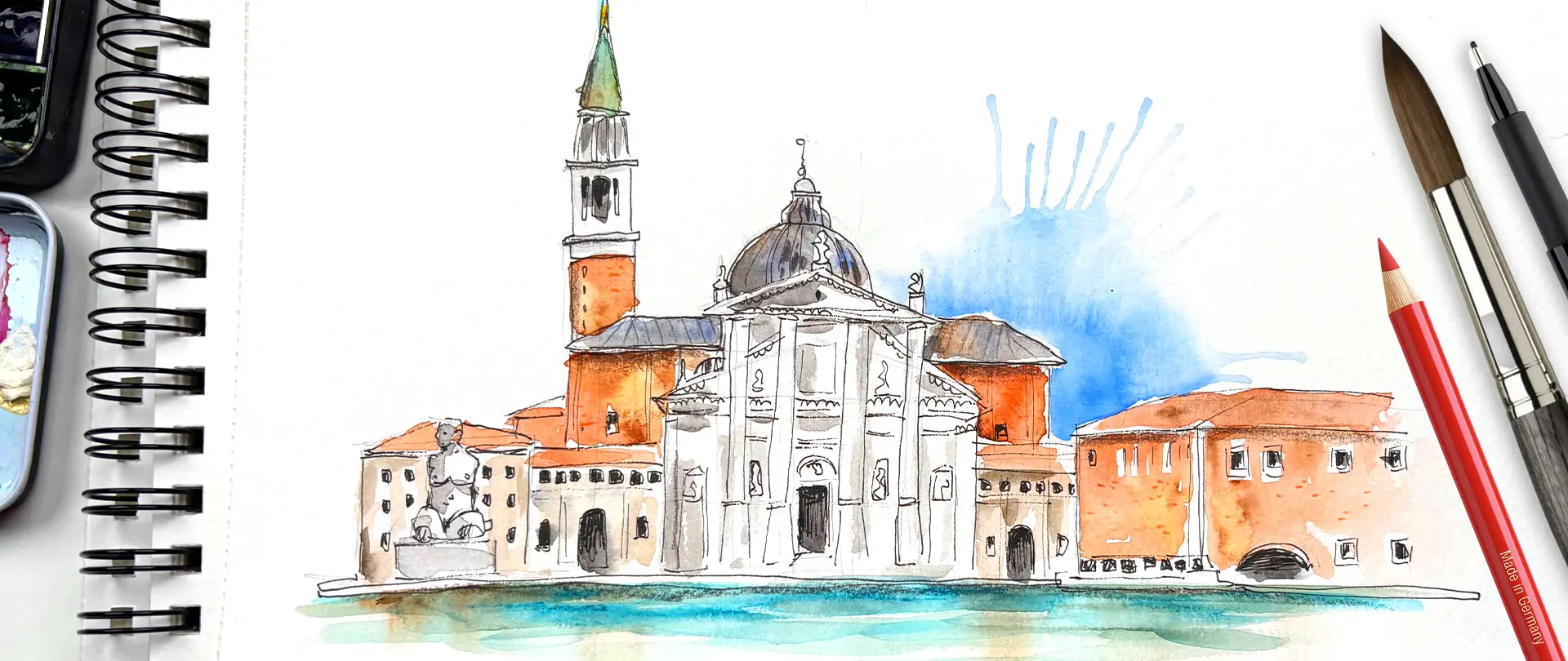 Aquarellskizze eines venezianischen Gebäudes mit Kuppel und Turm, umgeben von Künstlerwerkzeugen wie Pinsel, Stift und Zeichenblock für Urban Sketching Anfänger