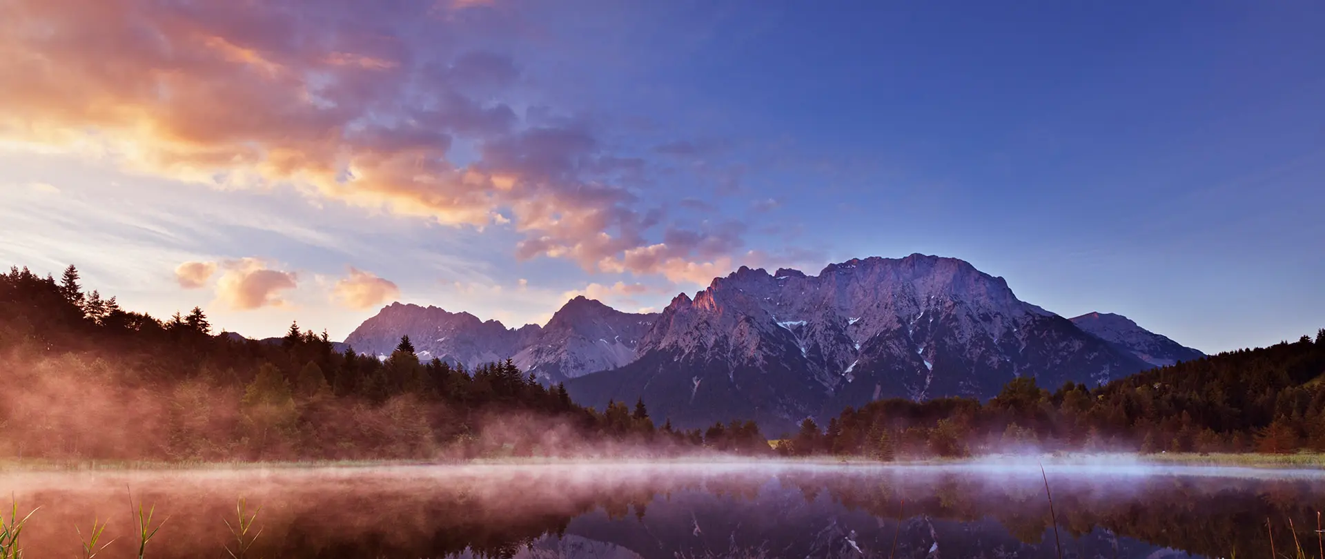Morgenstimmung mit Nebel über See und Bergen in den bayerischen Alpen als Beispiel für poetische Landschaftsfotografie