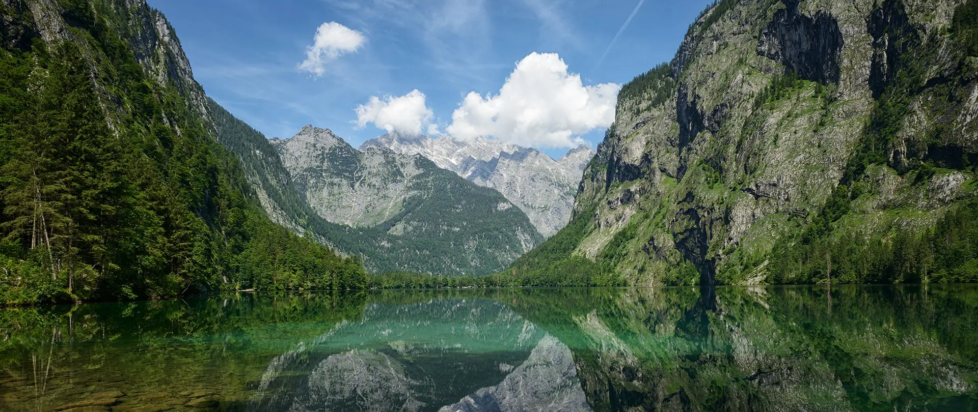 Spiegelung der Alpen und Felsen im klaren Wasser des Karwendelgebirges mit blauem Himmel und Wolken