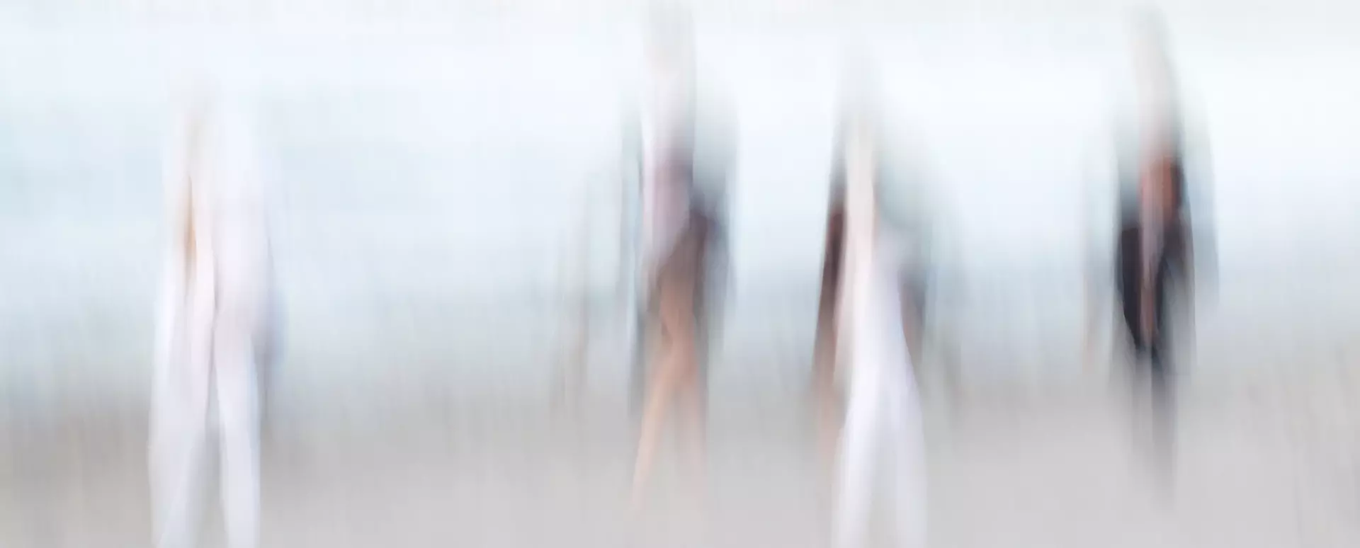 Unschärfe von vier Personen in Bewegung am Strand, symbolisiert den Flow-Zustand bei kreativem Fotografieren und völliger Konzentration