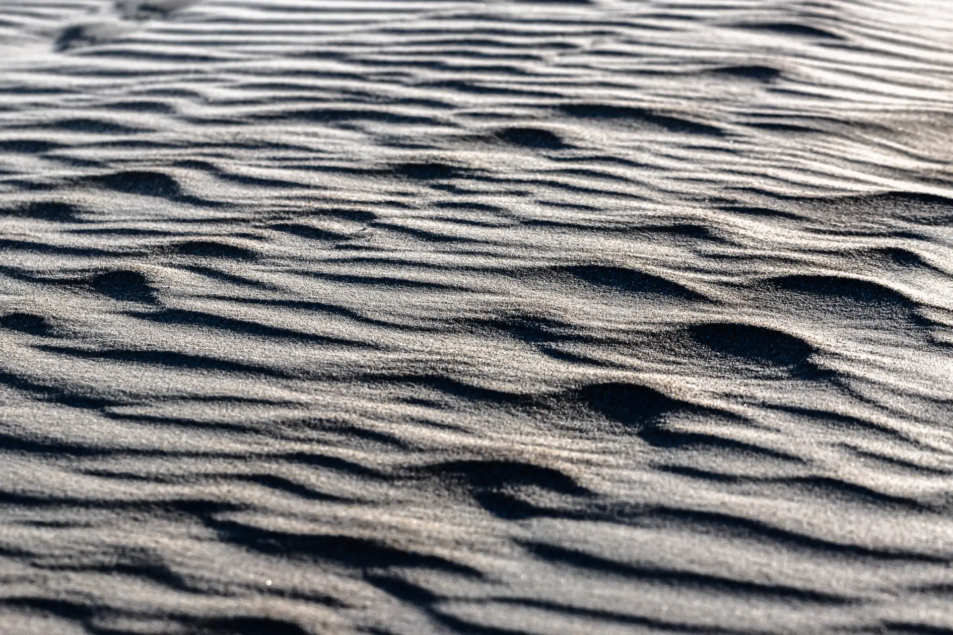 Feine Sandstrukturen mit Licht- und Schatteneffekten auf dem Strand der ruhigen Nordseeinsel Spiekeroog
