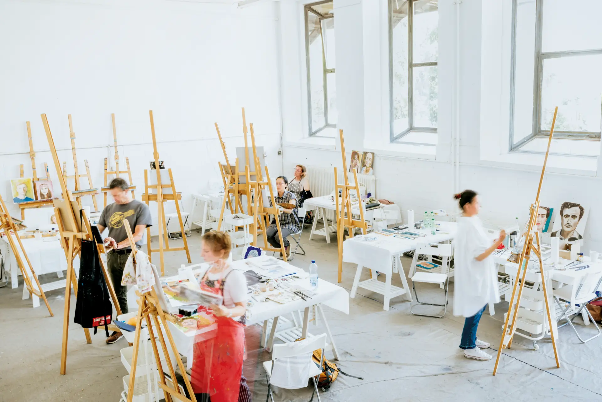Atelier Alte Molkerei von oben Kunstkurs in Worpswede mit mehreren Personen, die in einem hellen Atelier an Staffeleien porträtieren
