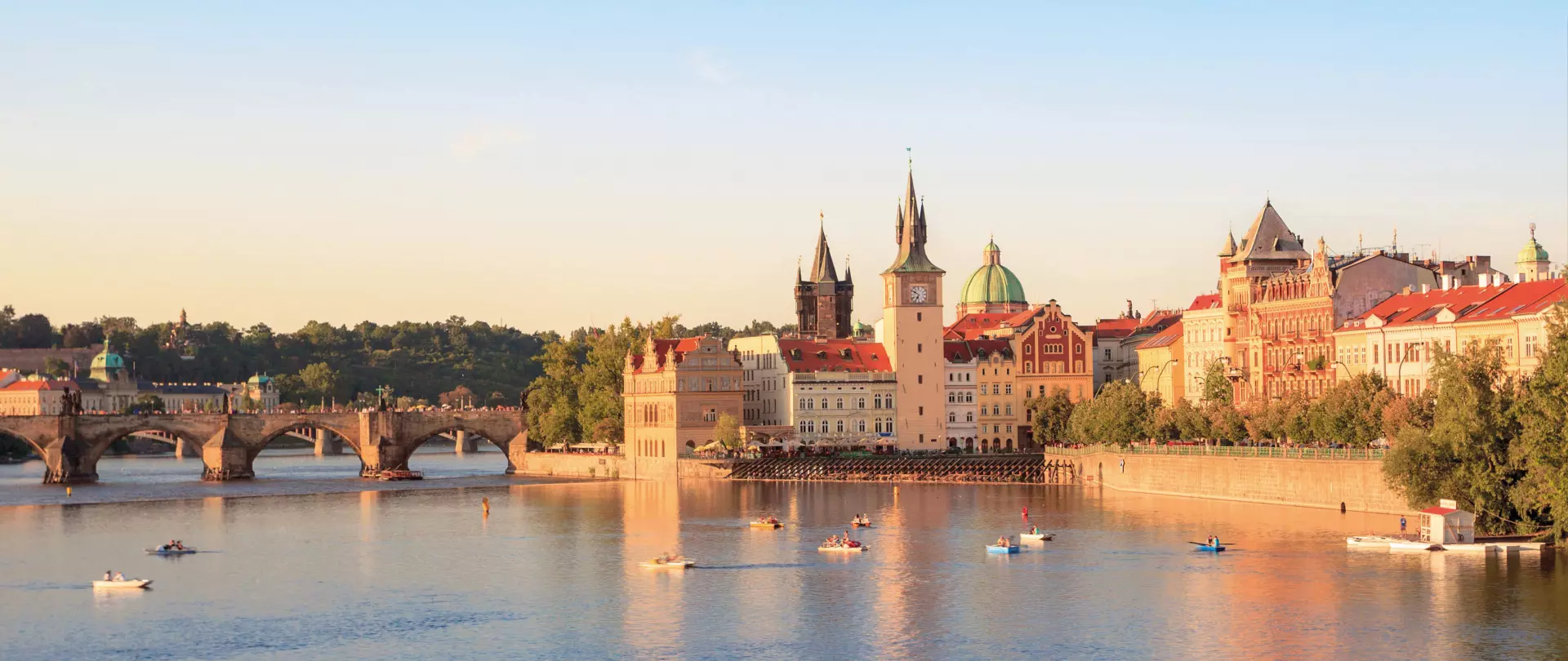 Panoramablick auf die Moldau mit der Karlsbrücke und historischen Gebäuden in Prag bei Sonnenuntergang