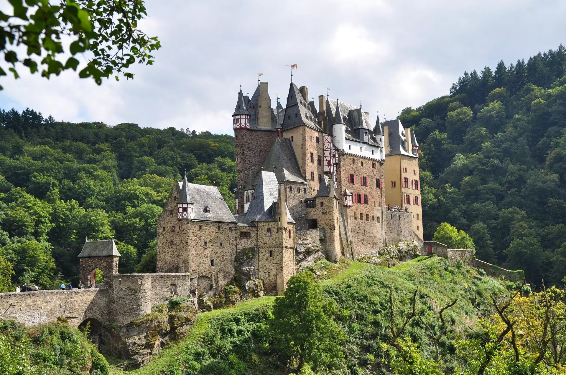 Burg in der Moselregion Mittelalterliche Burg auf einem Hügel umgeben von Wald und grüner Landschaft in der Moselregion