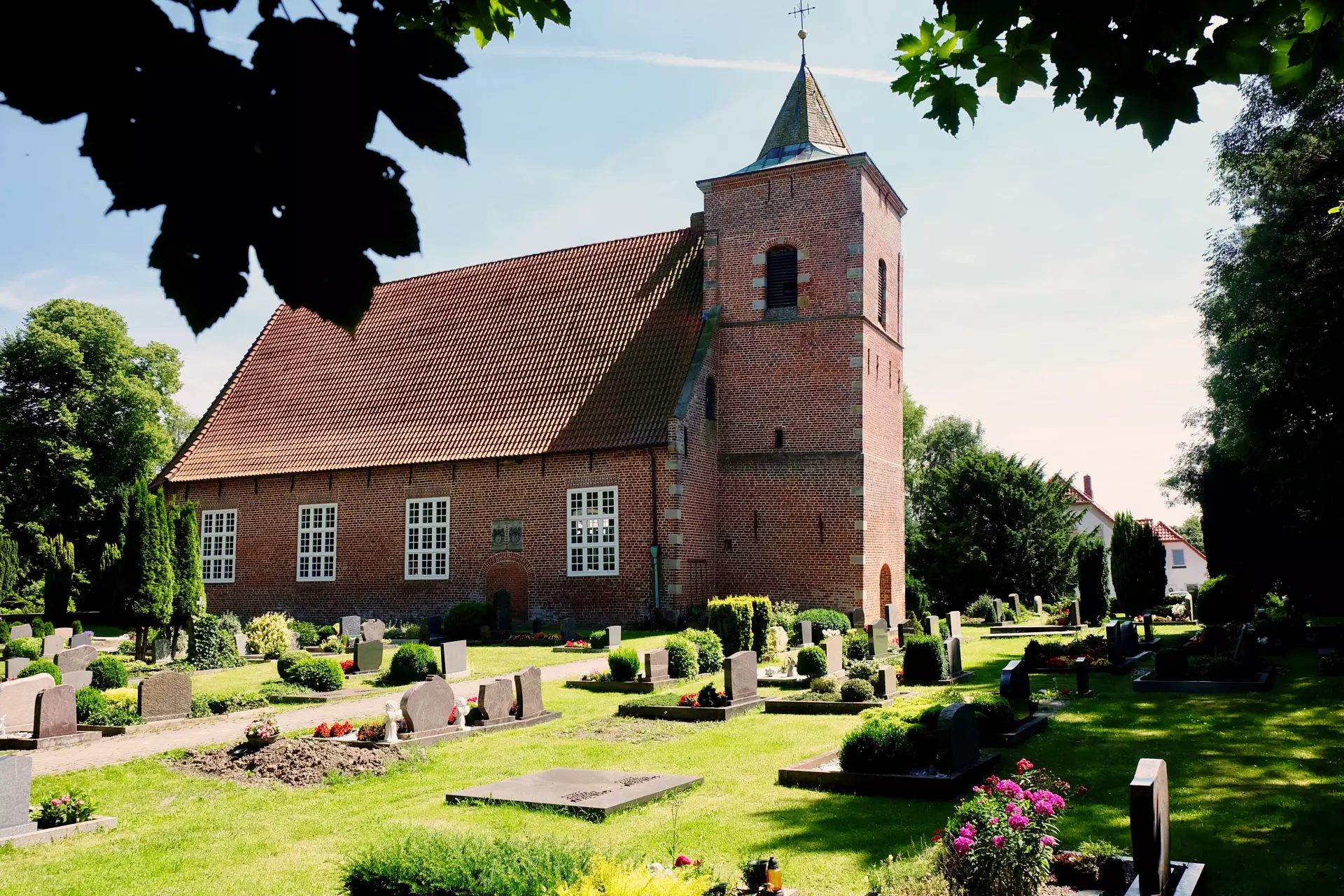 Alte Kirche Seefeld Backsteinkirche mit rotem Ziegeldach und umliegendem Friedhof im Wattenmeer bei sonnigem Wetter