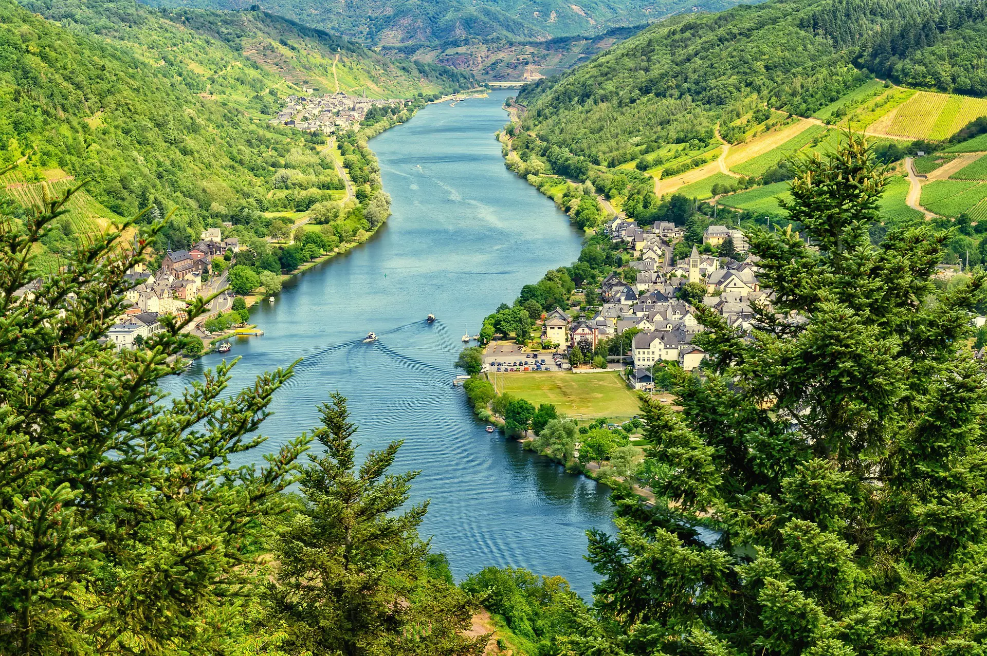 Fluss Mosel Fluss Mosel mit grünen Weinbergen und Dörfern an den Ufern, zwei Boote fahren auf dem Wasser, umgeben von bewaldeten Hügeln