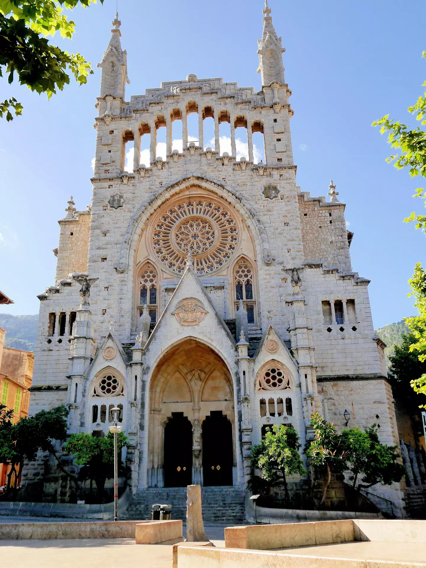 Kirche auf Mallorca Gotische Kirche mit großer Rosette und verzierten Bögen vor blauem Himmel in Mallorca