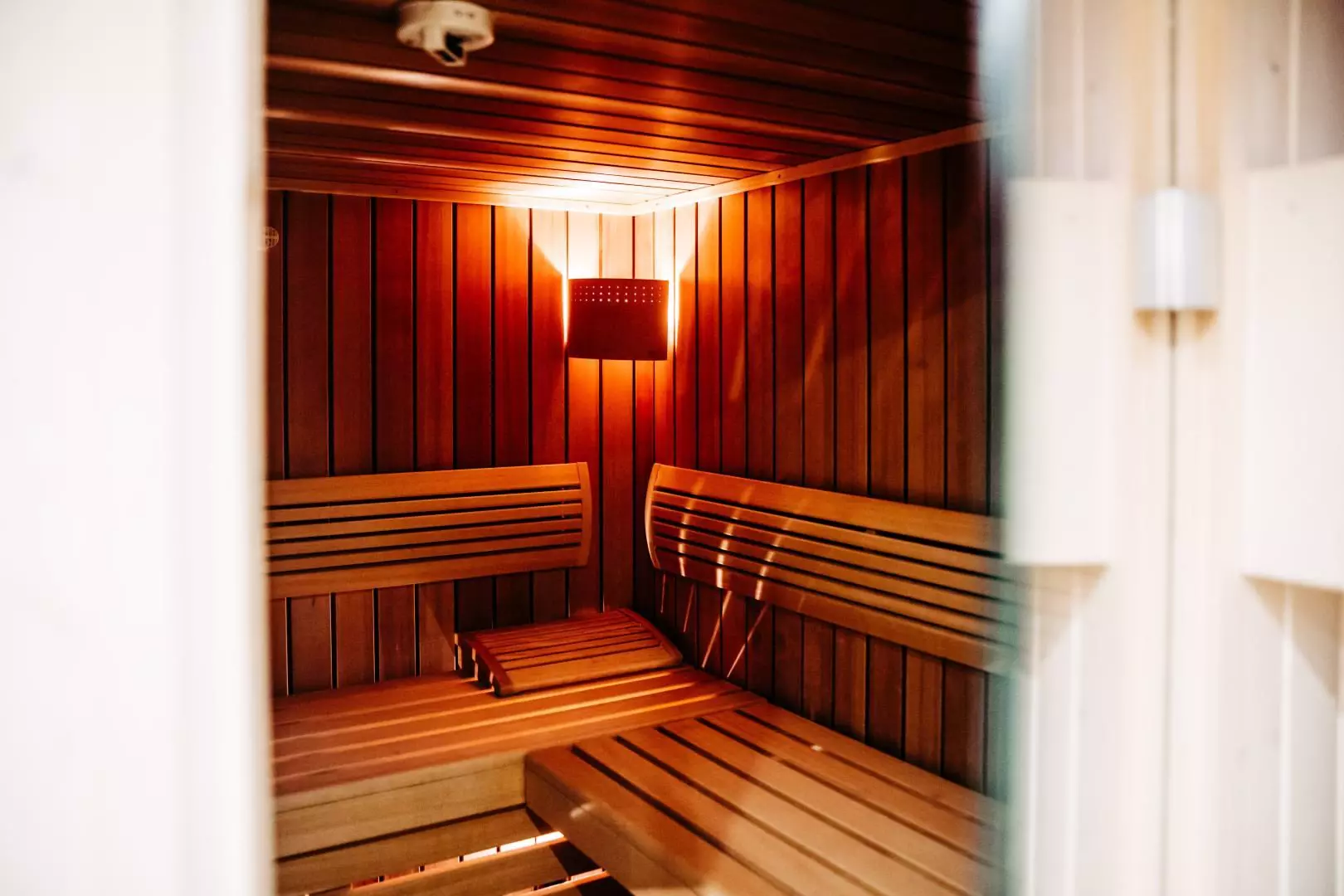 Sauna mit Holzbänken und warmem Licht im Hotel Messmer Bregenz zur entspannten Erholung