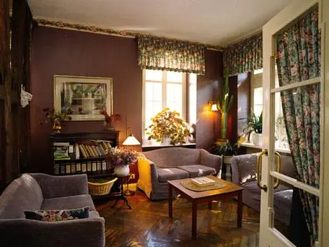 Gemütliches Wohnzimmer mit Sofas, Holztisch, Bücherregal und großen Fenstern im Landhaus Arnoth Moselregion