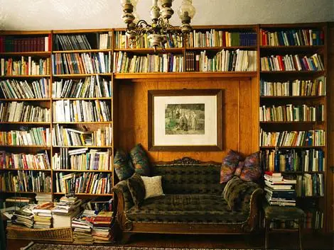 Gemütliches Wohnzimmer im Landhaus Arnoth mit Bücherregalen, Sofa, dekorativen Kissen und einem Bild an der Wand in der Moselregion