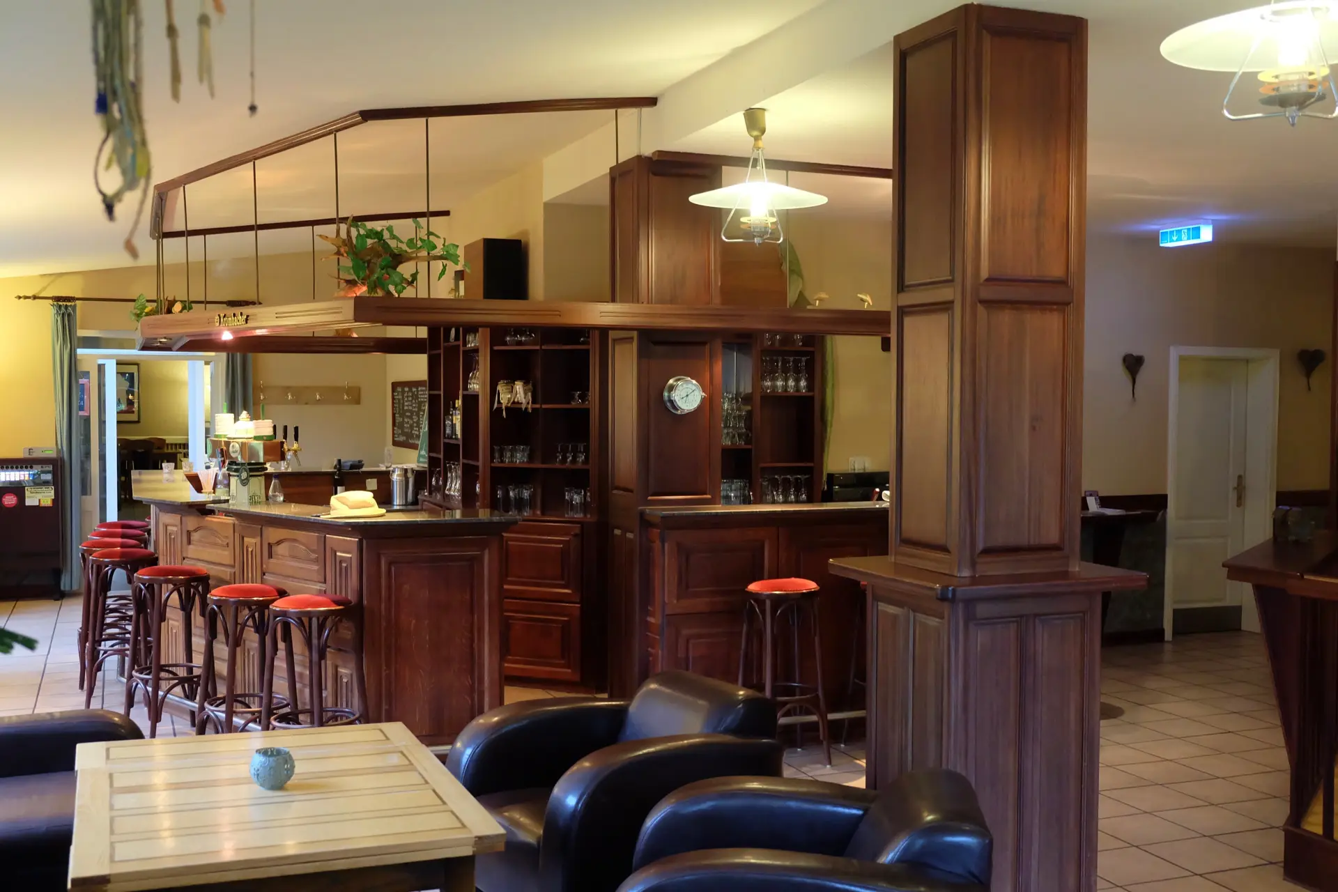 Jadebusen Kunzehof Speiseräume und Zimmer Seefeld Gemütliche Hotelbar mit Holztheke, roten Barhockern und Ledersesseln im Seminarhotel Kunze-Hof in Wattenmeer