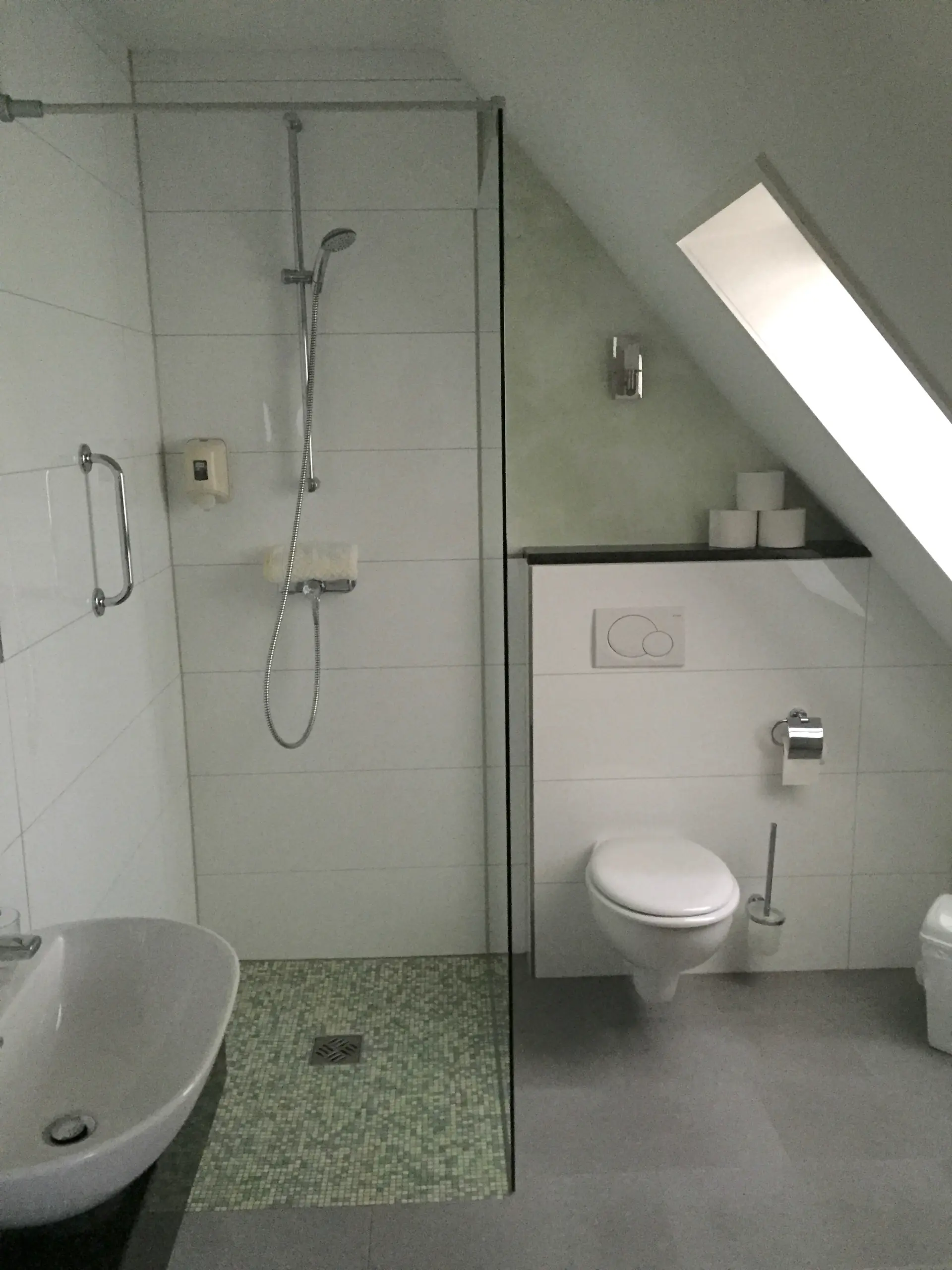 Badezimmerbeispiel Modernes Badezimmer im Seminarhotel Kunze-Hof mit Dusche, Waschbecken, WC und Dachfenster im Wattenmeer