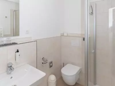 Modernes Badezimmer im Kurhotel Sassnitz auf Rügen mit Waschbecken, Toilette und Duschecke in hellen Farben