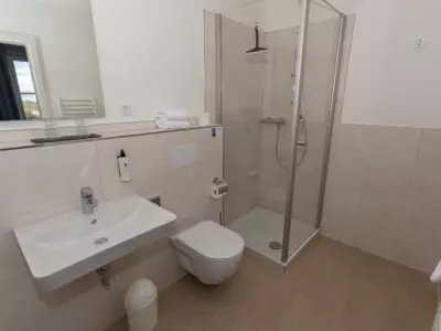 Modernes Badezimmer mit Dusche, WC und Waschbecken im Kurhotel Sassnitz auf Rügen