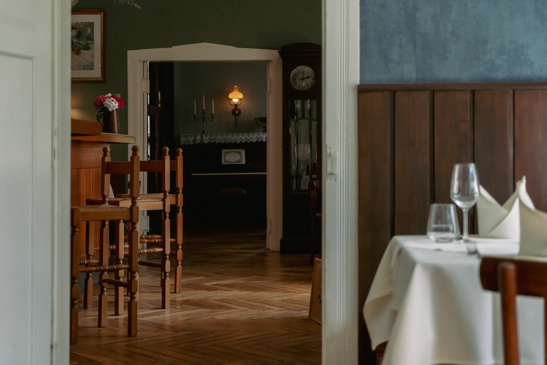 Rustikal eingerichteter Speisesaal im Landhaus Arnoth mit Holzmöbeln, gedecktem Tisch und Blick in einen angrenzenden Raum