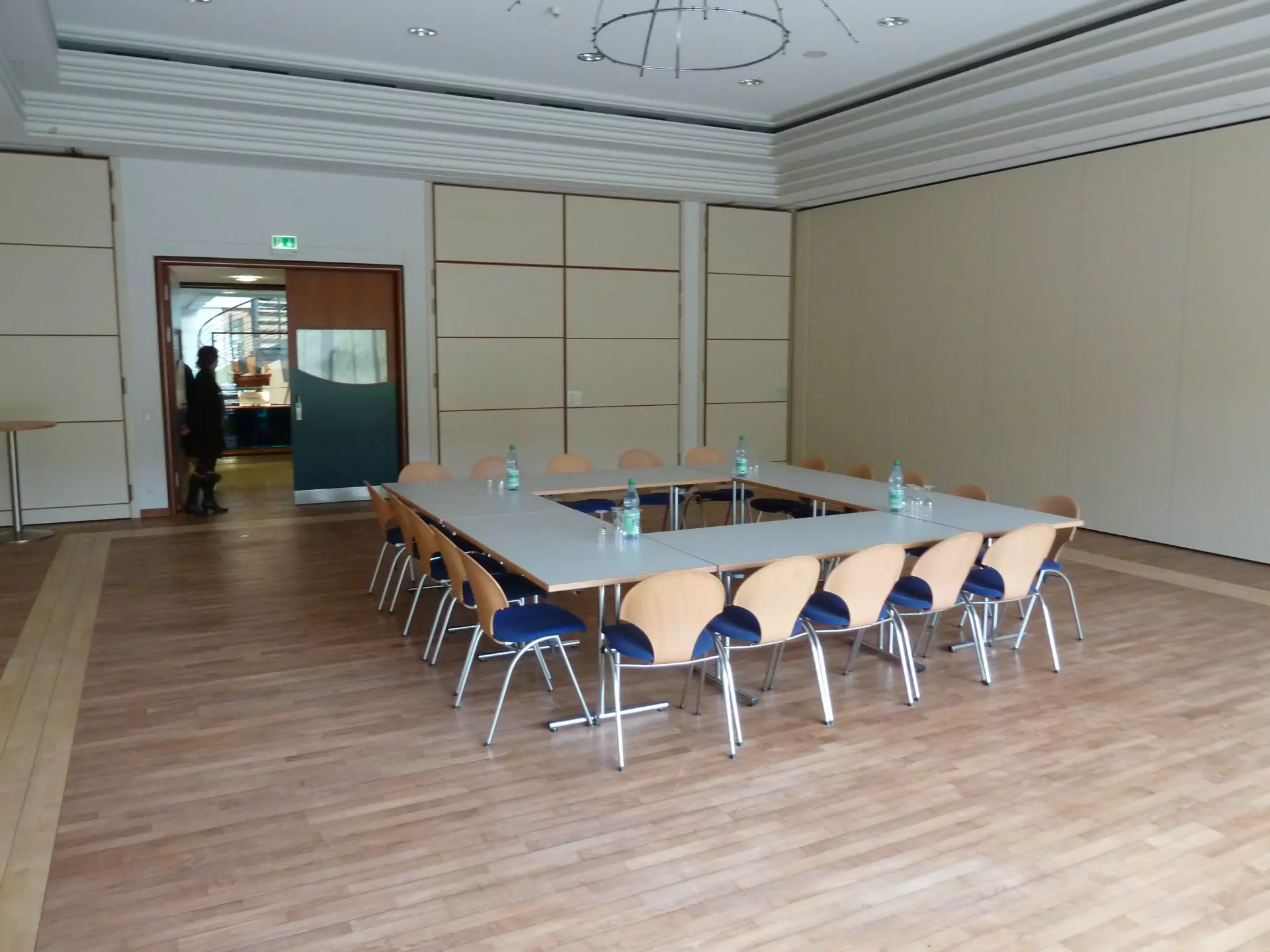 Konferenzraum im Atelier „Haus des Gastes (Raum: Kogge)" auf Spiekeroog mit mehreren Stühlen um quadratische Tische und Holzboden