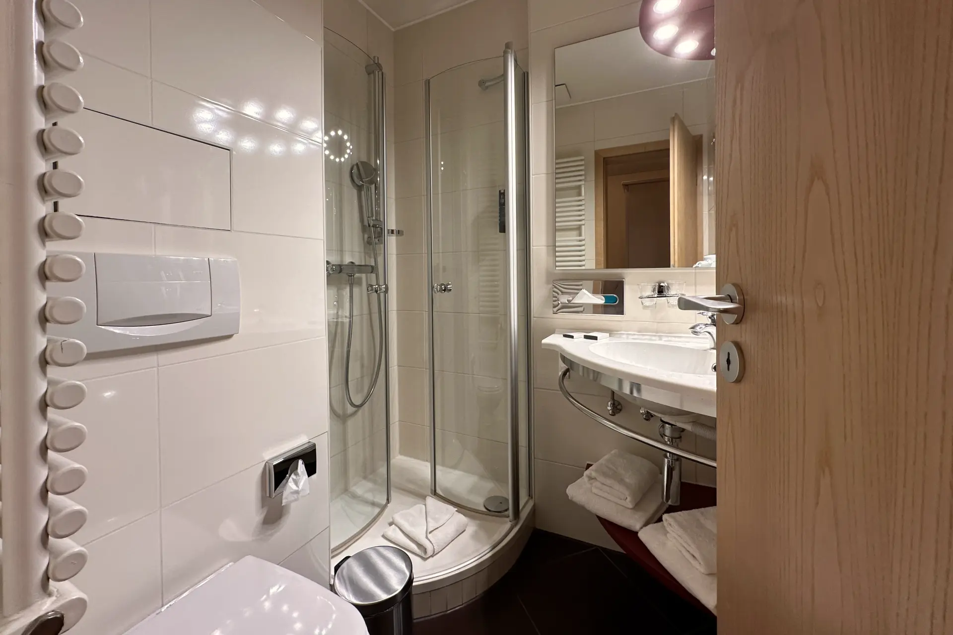 Modernes Badezimmer mit Dusche, Waschbecken, WC und Handtüchern im Parkhotel Bad Schandau, Sächsische Schweiz
