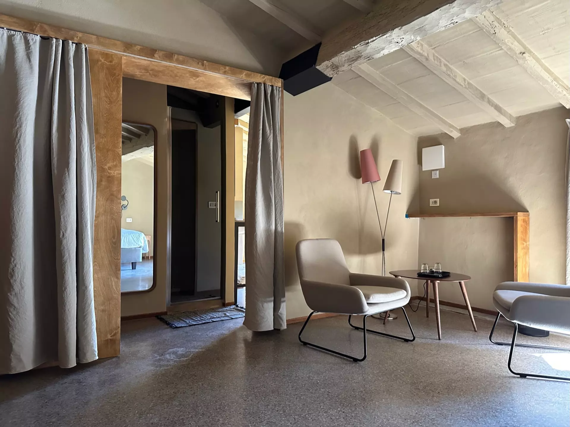 Doppelzimmer Moderne Sitzecke mit zwei Sesseln, kleinem Holztisch und Stehlampen in rustikal-gemütlichem Zimmer der Unterkunft Toskana