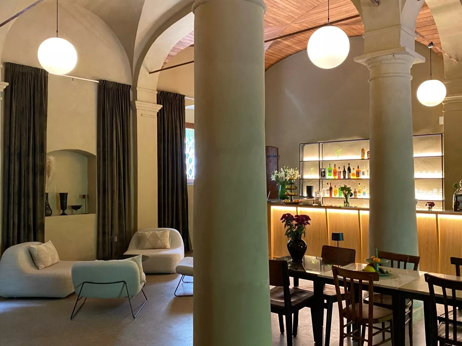 Einladene Lounge mit Bar Moderne Lounge mit gemütlichen Sesseln, Holztisch und stilvollem beleuchtetem Barbereich in einer Unterkunft in der Toskana