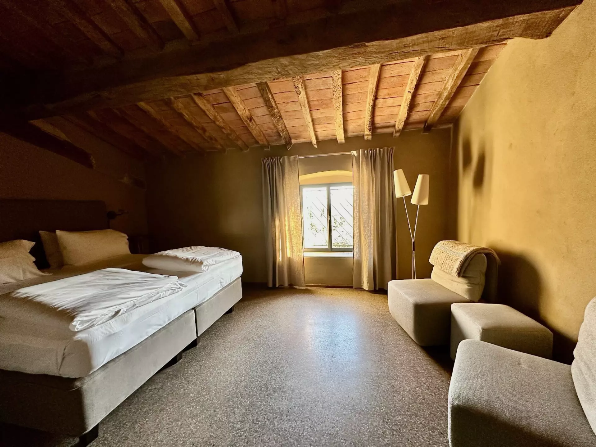 Doppelzimmer Rustikales Schlafzimmer mit Holzbalkendecke, zwei Einzelbetten, Fenster mit Vorhängen und Sitzbereich in der Unterkunft Toskana