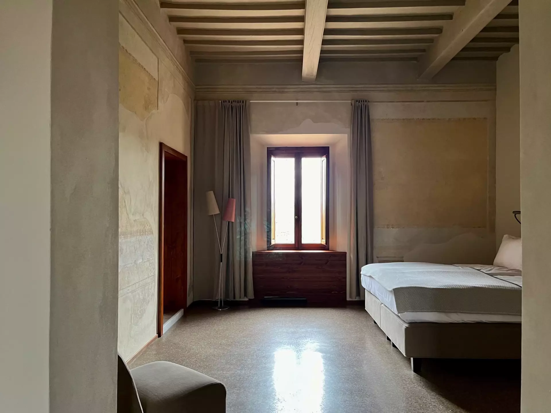 Doppelzimmer Ansicht 2 Helles Schlafzimmer mit Holzdeckenbalken, Doppelbett, Vorhängen und Fenster in der Unterkunft Toskana