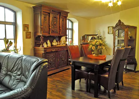 Esszimmer mit antiken Holzmöbeln, Lederstühlen, Ledersofa und Blumendekoration im Hotel Birschel-Mühle in Hattingen