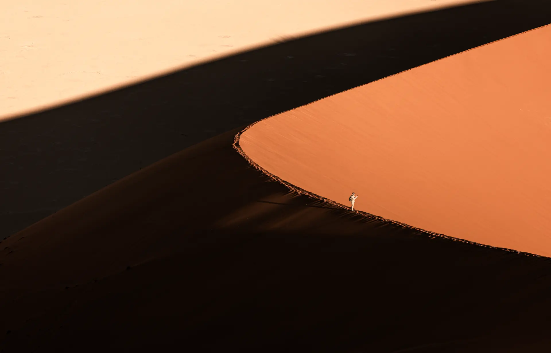 Minimalistische Sanddünen-Landschaft mit einem kleinen Wanderer auf dem Grat, gestaltet von Urs Renggli mit Fokus auf Ruhe und meditative Ordnung