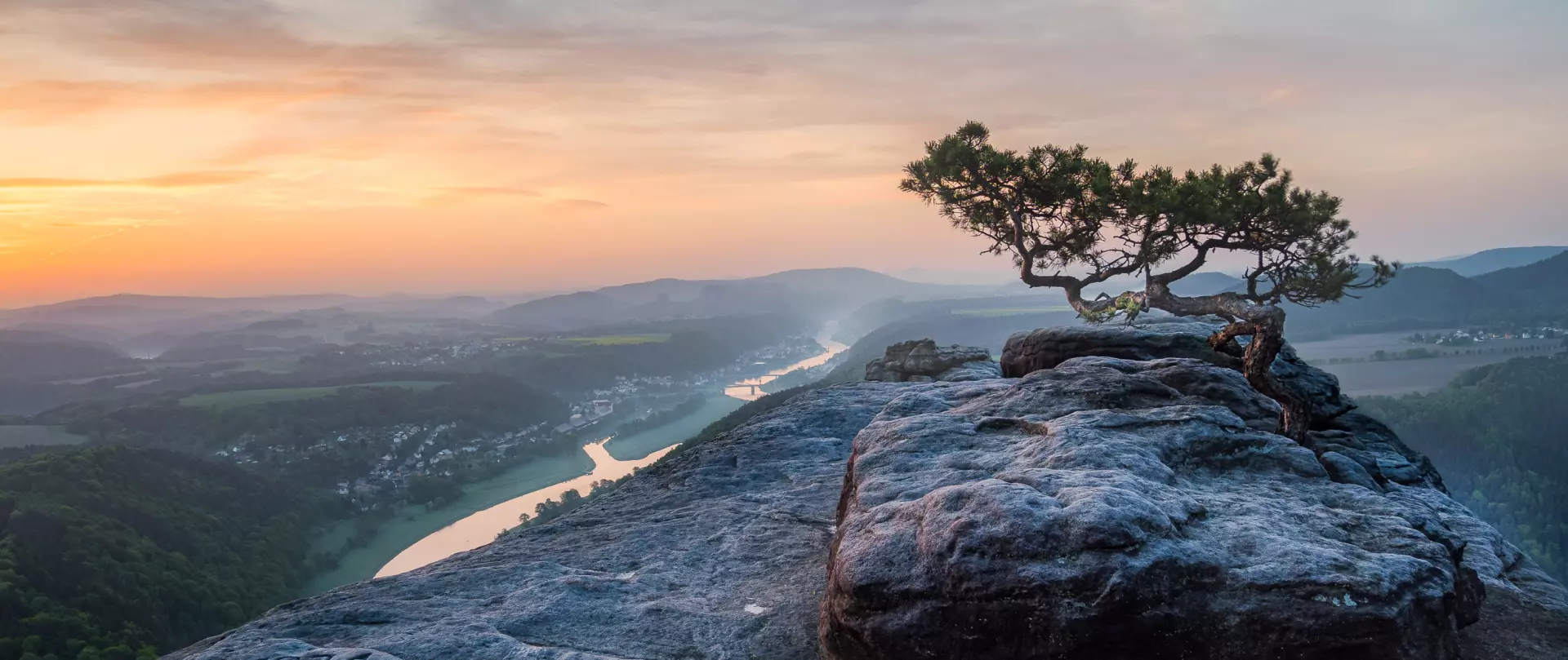 Felsvorsprung mit Baum bei Sonnenaufgang über Flusslandschaft, Naturaufnahme von Helmut Kruse mit Fokus auf Licht und Perspektive