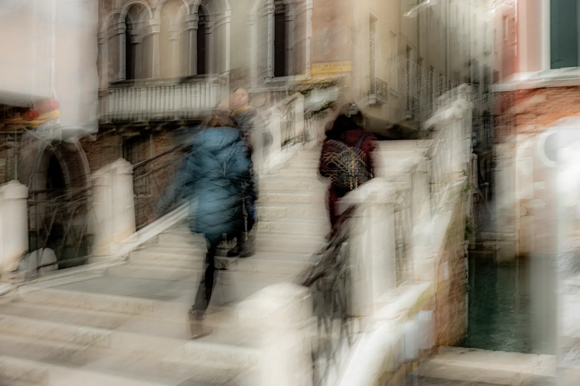 Menschen in Bewegung auf einer Brücke in Venedig mit bewusster Unschärfe und diffuser Lichtstimmung von Urs Renggli