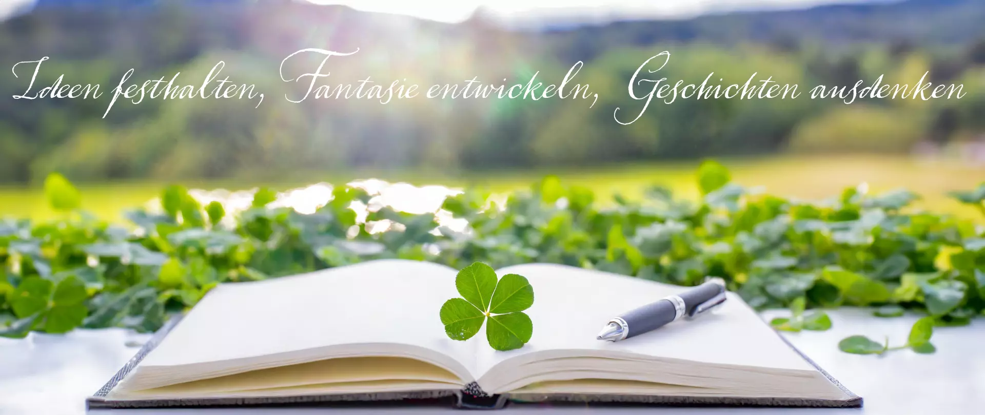 Offenes Notizbuch mit Kleeblatt und Stift vor grünem Wasser-Hintergrund, Symbol für Christiane Höhmanns kreative Natur- und Menschennähe in ihren Romanen