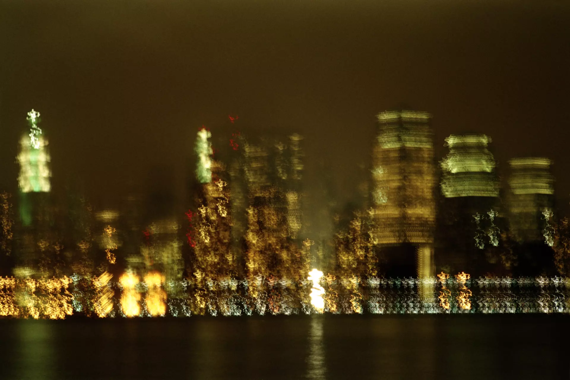 Nachtaufnahme einer Stadt Nachtaufnahme einer Stadt, die durch Unschärfe und Lichtspuren abstrahiert ist – Abstrakte Fotografie von artistravel Dozent Jürgen Wassmuth