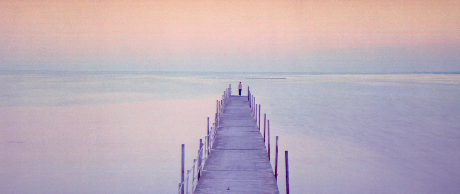 Steeg am See Langer Steg, der in der Ferne in einer diffusen, pastellfarbenen Nebellandschaft verschwindet – Abstrakte Fotografie von artistravel Dozent Jürgen Wassmuth