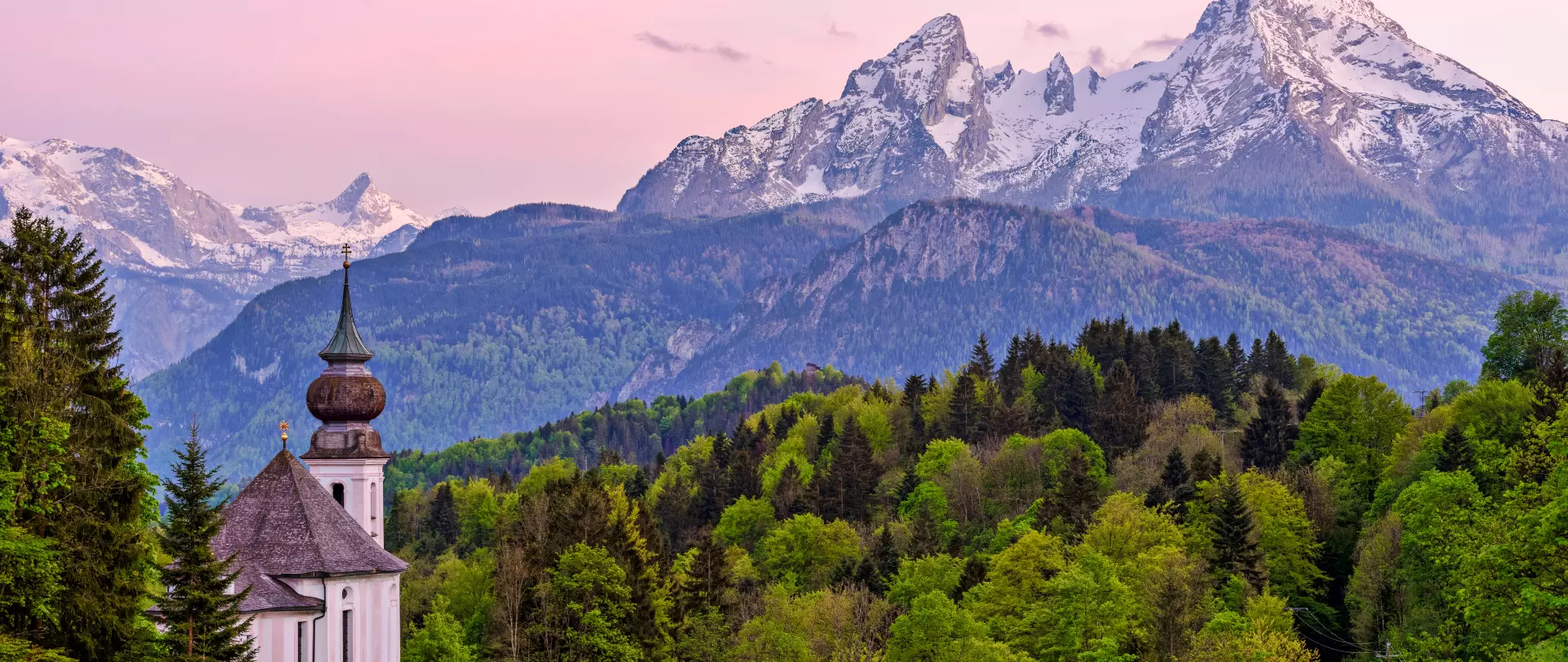 Mark Robertz fängt in dieser Landschaftsfotografie die Kirche vor dem Alpenpanorama im sanften Abendlicht ein, das Natur und Seele verbindet