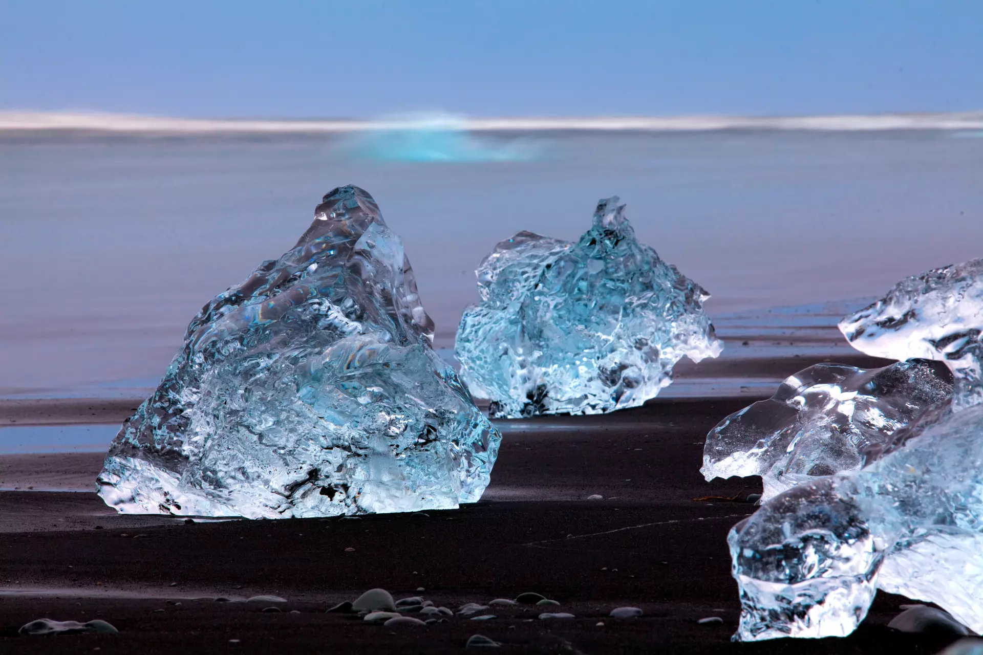 Eis am Strand Glänzende Eisbrocken auf einem schwarzen Strand mit diffuser Lichtquelle – Abstrakte Naturfotografie von artistravel Dozent Uwe Schmid