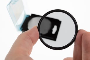Eine Hand hält einen Polfilter.