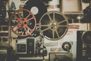 Photo by Noom Peerapong on Unsplash Ein Foto von einem sehr alten Videoprojektor